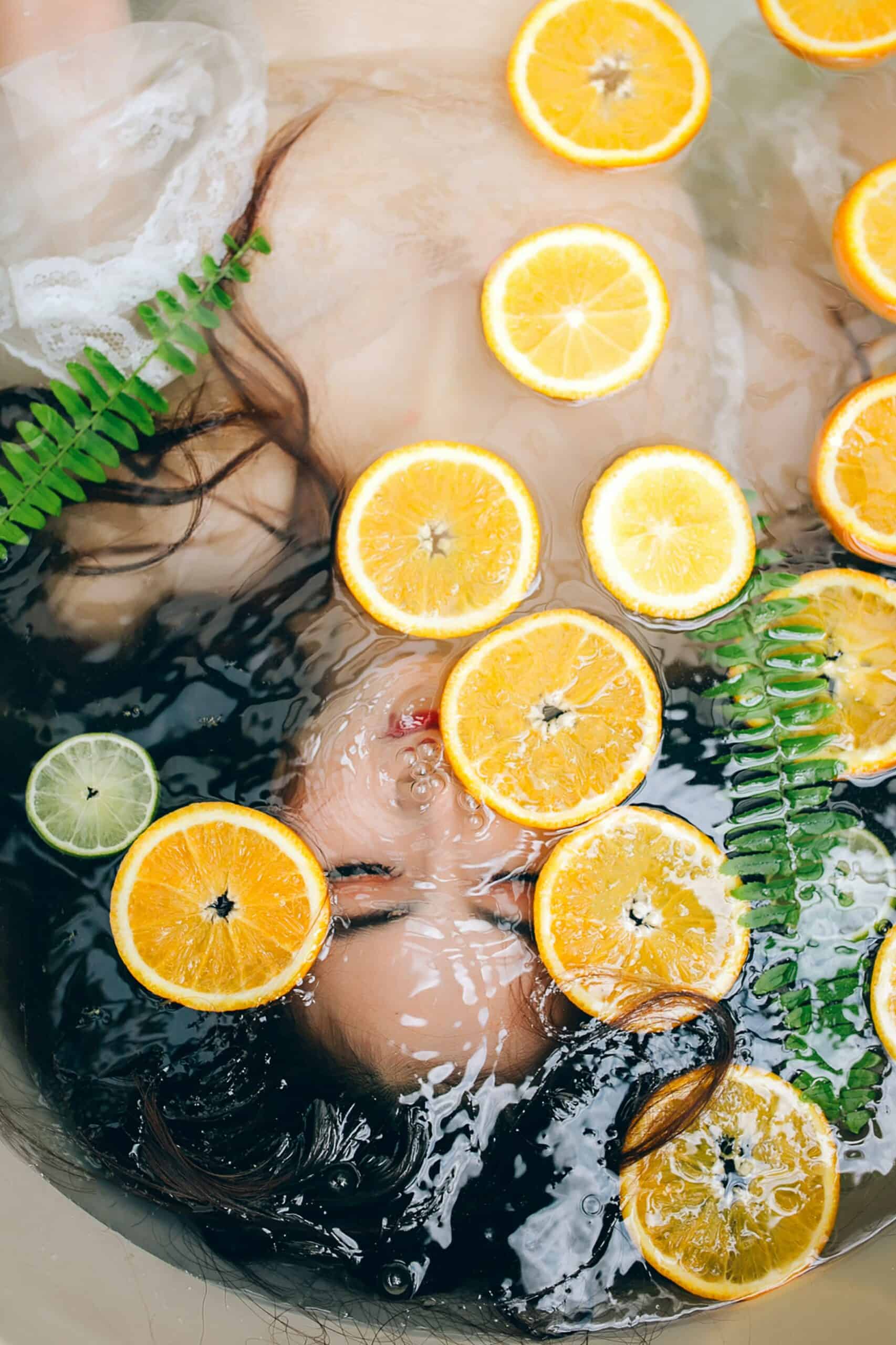 Frau badet in Orangen